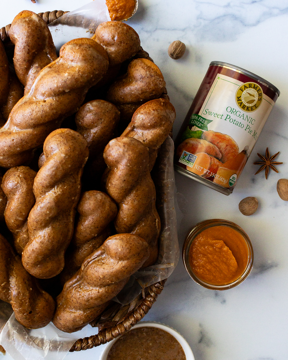 a plate of gf glazed sweet potato donuts with a can of Farmer's Market Sweet Potato Pie Mix