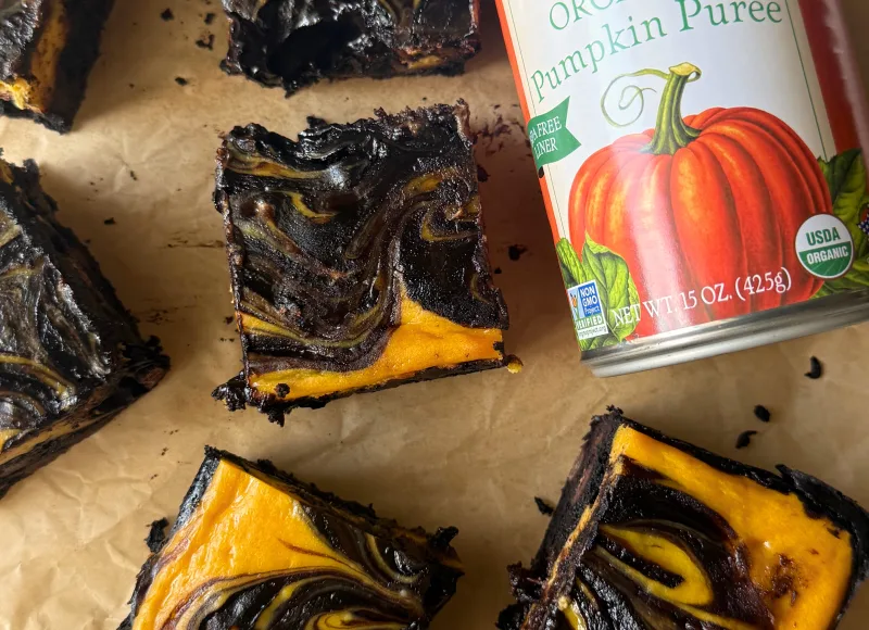cut pumpkin cheesecake bars with a can of Farmer's Market Foods Organic Pumpkin Puree