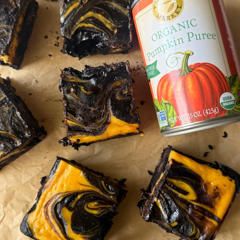 cut pumpkin cheesecake bars with a can of Farmer's Market Foods Organic Pumpkin Puree